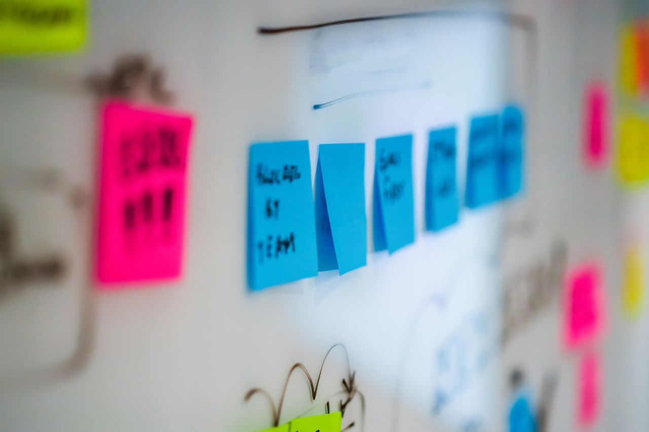 Services Sticky notes on a whiteboard during a creative brainstorming session in an office.